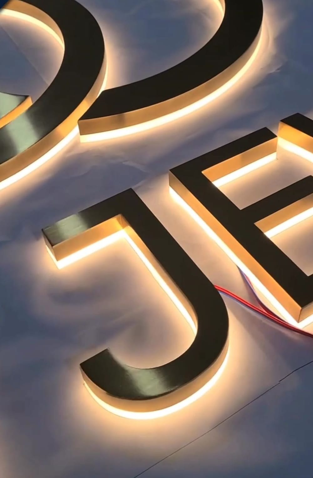 Close-up of backlit three-dimensional letters with the LED wiring still visible behind one of them.